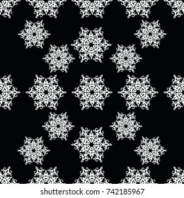 Seamless texture.  White snowflakes on a black background