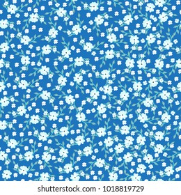 Seamless tiny cute flower, floral vector background. White flowers on a blue background.