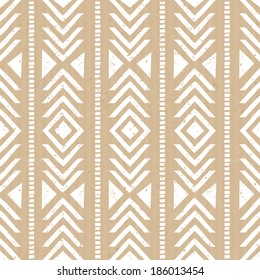 Seamless tribal aztec pattern in white against cardboard paper background.