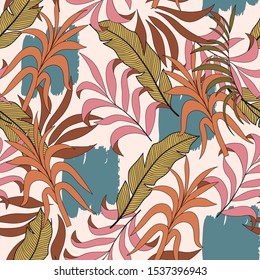 Seamless tropical pattern with a colorful yellow leaves and flowers on a pastel background. Trendy summer Hawaii print. Beautiful seamless vector floral pattern.