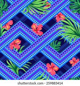 seamless tropical pattern on a tribal background. overlapping geometrical shapes with hibiscus flowers and palm leaves. fashion print