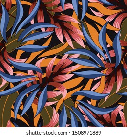 Seamless tropical pattern with plants and leaves in blue and Yellow on black background. Beautiful exotic plants.  Seamless exotic pattern with tropical plants. Tropic leaves in bright colors.