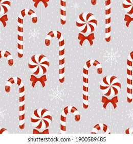 Seamless vector background with candy. Christmas pattern with candy canes and reeds. Vector background for printing, winter holidays, greeting cards, fabric, textiles, wrapping paper.