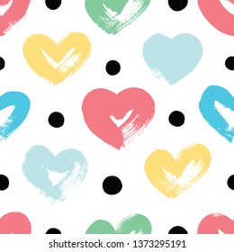 Seamless vector background with hearts in pastel colors. Drawn with a dry brush.