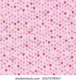 A seamless vector, blending pattern of pink and red hearts irregularly scattered on a light pink background. Great for digital Valentines projects backgrounds, fabrics, or gift wraps.