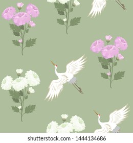 Seamless vector illustration with chrysanthemums and crane birds on a green background. For decoration of textiles, packaging, web design.