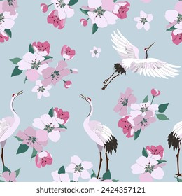 Seamless vector illustration with flowers cherry and cranes on a blue background. For decoration of textiles, packaging, wallpaper.