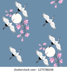 Seamless vector illustration with pink magnolia flowers and crane birds on a blue background. For decorating textiles, packaging, wallpaper.