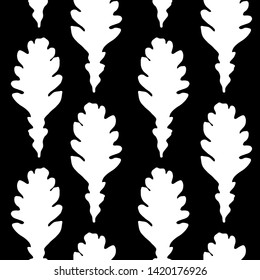 Seamless vector pattern of autumn leaf silhouettes.White silhouettes of oak leaves on black background.For decor fabric, paper, packaging, Wallpaper. Black and white graphics.