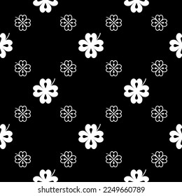 Seamless vector pattern with clover leaves. The holidays backdrop for St. Patrick's Day. White elements on the black. Festive background for greeting cards, decoration, packaging design, print and web