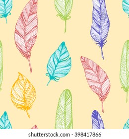 Seamless vector pattern with colored feathers in bohemian style on yellow. Ink drawn vector illustration for prints, fabric, wrapping and other design.