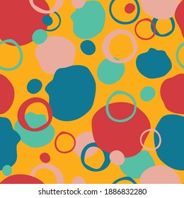 Seamless vector pattern with colourful splodges on yellow background. Bright artistic paint stain wallpaper design. Happy retro decorative fashion textile texture.