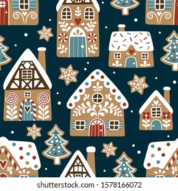 Seamless vector pattern with cute gingerbread houses and cookies on dark blue background. Perfect for textile, wallpaper or print design.