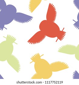Seamless vector pattern with green, red, yellow and purple owls. Repetitive background with vector flat multicolored birds. Owls in the repetitive seamless vector pattern.