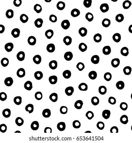 Seamless vector pattern with hand drawn black circles scattered on white background. Modern abstract design for print or textile.