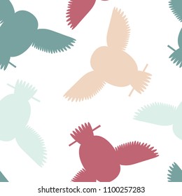 Seamless vector pattern with orange, teal, red owls. Repetitive background with vector flat multicolored birds. Owls in the repetitive seamless vector pattern.
