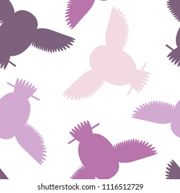 Seamless vector pattern with pink and purple owls. Repetitive background with vector flat multicolored birds. Owls in the repetitive seamless vector pattern.