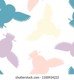 Seamless vector pattern with pink, yellow, violet, blue owls. Repetitive background with vector flat multicolored birds. Owls in the repetitive seamless vector pattern.