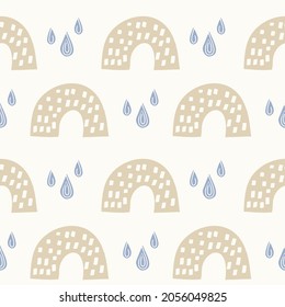 Seamless vector pattern with rainbows and rain drops. Scandinavian style hand drawn doodle background in pastel boho colors beige and light blue. For fabric textile, nursery wallpapers, gift wrapping.