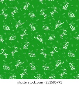 Seamless vector pattern with white Easter rabbits over green background