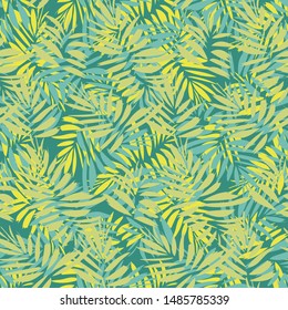 A seamless vector tropical pattern with overlapping palm leaves in yellow and teal green. Surface print design.