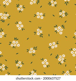 Seamless vintage pattern abstract. mustard background. small white flowers. green leaves. vector texture. trend print for textiles and wallpaper.

