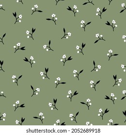 Seamless vintage pattern abstract. small white flowers and black leaves on a green background. vector texture. trend print for textiles, wallpaper and packaging.