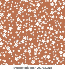 Seamless vintage pattern abstract . terracotta background. small white flowers. vector texture. trend print for textiles and wallpaper.