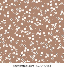 Seamless vintage pattern. Light brown background. small white flowers. Vector texture. fashionable print for textiles and wallpaper.