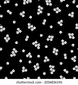Seamless vintage pattern. Small white flowers on a black background. Vector texture. Trend print for textiles and wallpaper.