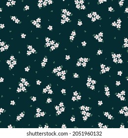 Seamless vintage pattern. Small white flowers, green leaves on a dark green background. vector texture. trend print for textiles and wallpaper.