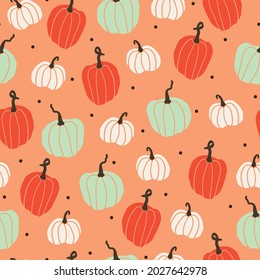 Seamless vintage pattern . white, green and orange pumpkins on a light orange background. Vector texture. trend print for textiles and wallpaper.