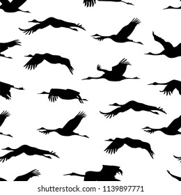 Seamless wallpaper with silhouette flying Japanese cranes on white background. Monochrome black and white tiled sketch of birds