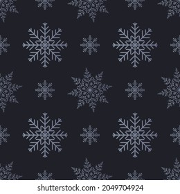 Seamless winter background with grey snowflakes on a dark background.