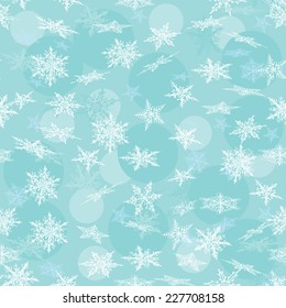 Seamless winter background with white snowflakes. Vector