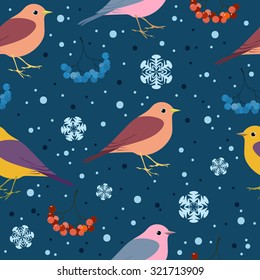 Seamless winter pattern with multicolored birds, ash berries and snowflakes in dark blue background. Christmas and New Year background.