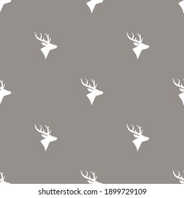 seamless winter pattern with silhouette of deer head with antlers. vector flat wild nature ornament on brown background