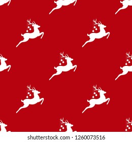 seamless winter pattern with white silhouette of deers with antlers and christmas tree toy balls on horns. vector flat Christmas ornament on red background