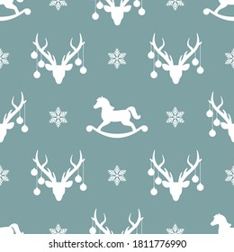 seamless winter pattern with white silhouette of deers with christmas tree toy balls on horns, toy horses and snowflakes. vector flat Christmas ornament on powder blue background