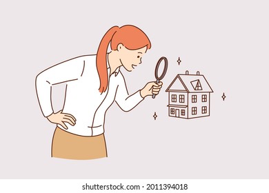 Searching for new house and real estate concept. Young positive business woman standing using magnifying glass zooming to see house or residential building details for making deal 