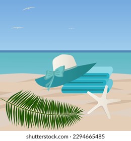 Seaside vacation concept. A stack of towels and a beach hat lie on a sandy beach, the composition is decorated with a starfish