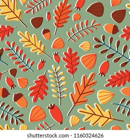 Seasonal seamless pattern with fallen autumn leaves, branches, berries and acorns on green background. Motley fall backdrop. Natural vector illustration for wrapping paper, wallpaper, textile print.