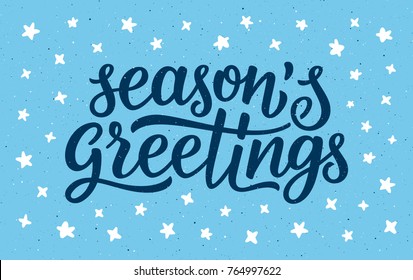 Seasons greetings calligraphy lettering text on blue background with white doodle stars. Retro greeting card for Christmas and New Year holidays. Vector background