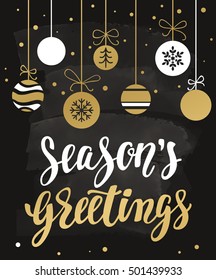 Season's greetings. Holiday greeting with calligraphy and decorative elements. Handwritten modern lettering with with xmas decorations on chalkboard dark background.