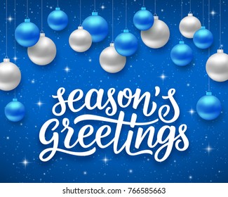 Seasons greetings script text on blue background with sparkles and colorful hanging balls. Vector illustration for holidays with lettering