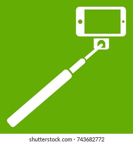 Selfie stick and smartphone icon white isolated on green background. Vector illustration