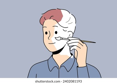 Self-sufficient man artist paints own face and hair with brush, creating self-portrait. Self-sufficient guy draws look, for concept of independence and personal improvements thanks to fortitude