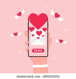 Sending love message. Hand holding cell phone with love heart on screen. Send or receive love sms, letter, email with mobile phone. 