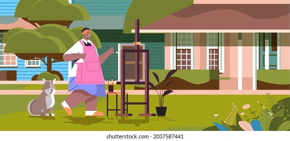 senior african american woman artist with dog painting picture on backyard lawn creative hobby concept