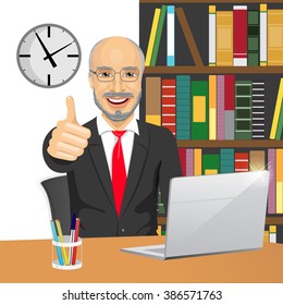 senior businessman making thumbs up hand sign at his office while working with laptop